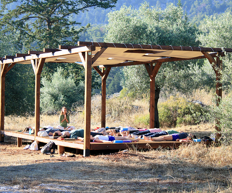 Outdoor yoga session under a wooden pergola at Agios Ioannis