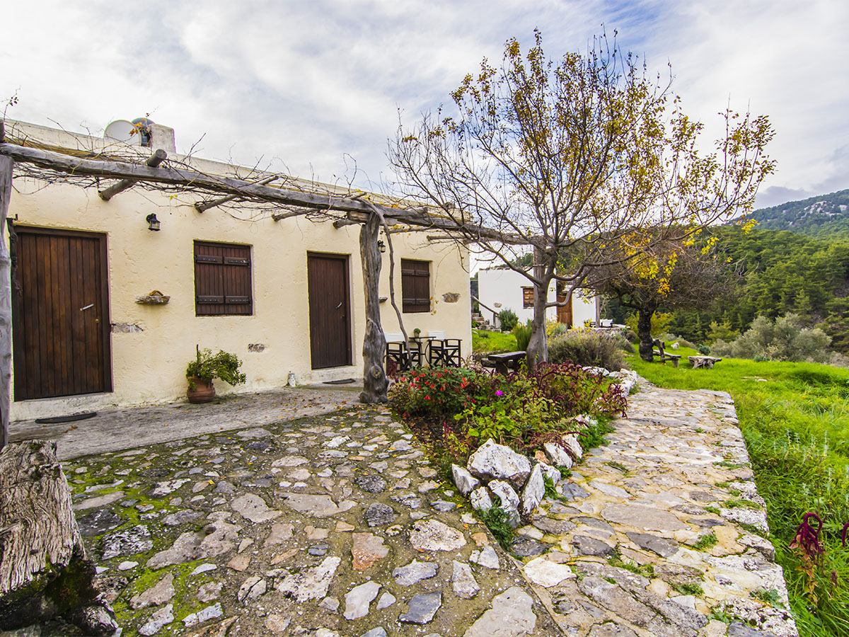 Row of guest room doors along the stone courtyard at Alonia