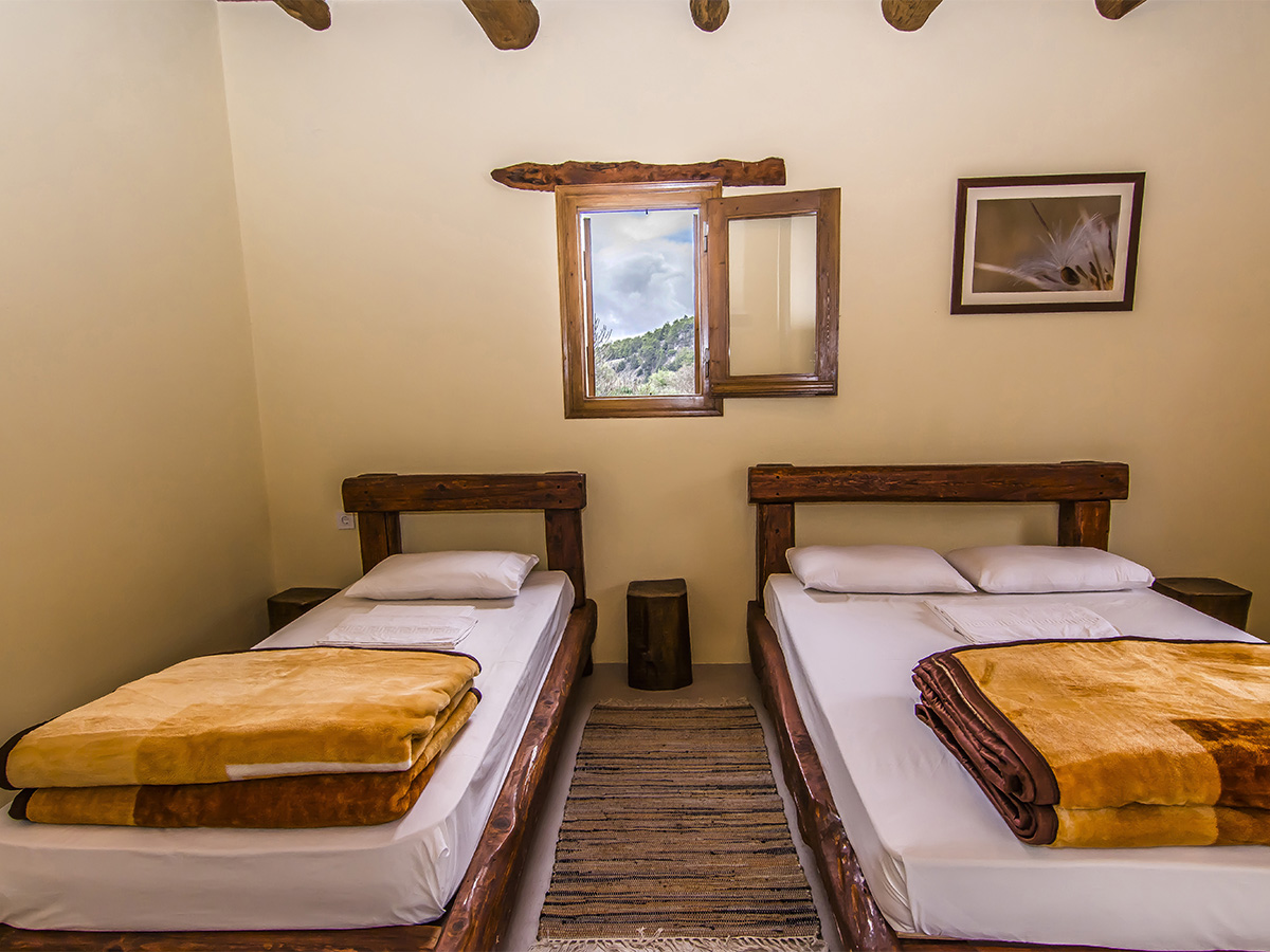 Twin and double room with wooden headboards and framed nature prints