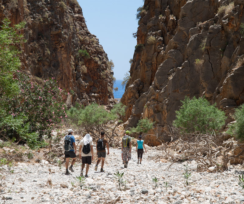 Hikers descending through the rock walls of Aradena Gorge